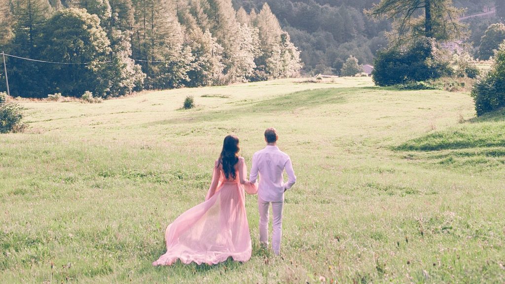 Jeunes mariés marchant dans un champ